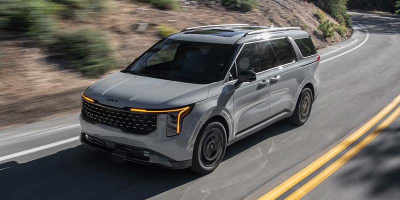 2026 Kia Carnival Hybrid driving on a mountain road