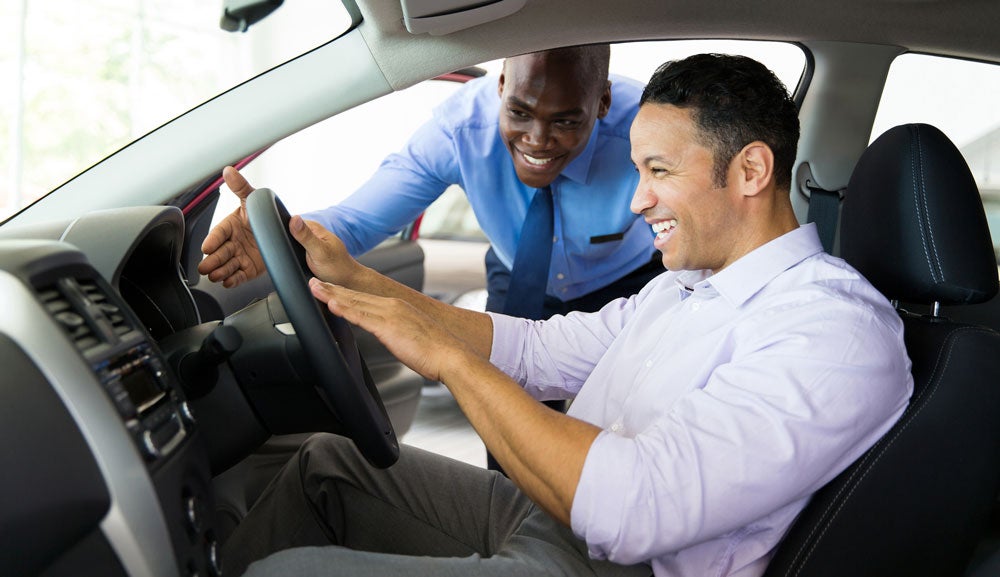 customer and salesman test driving car